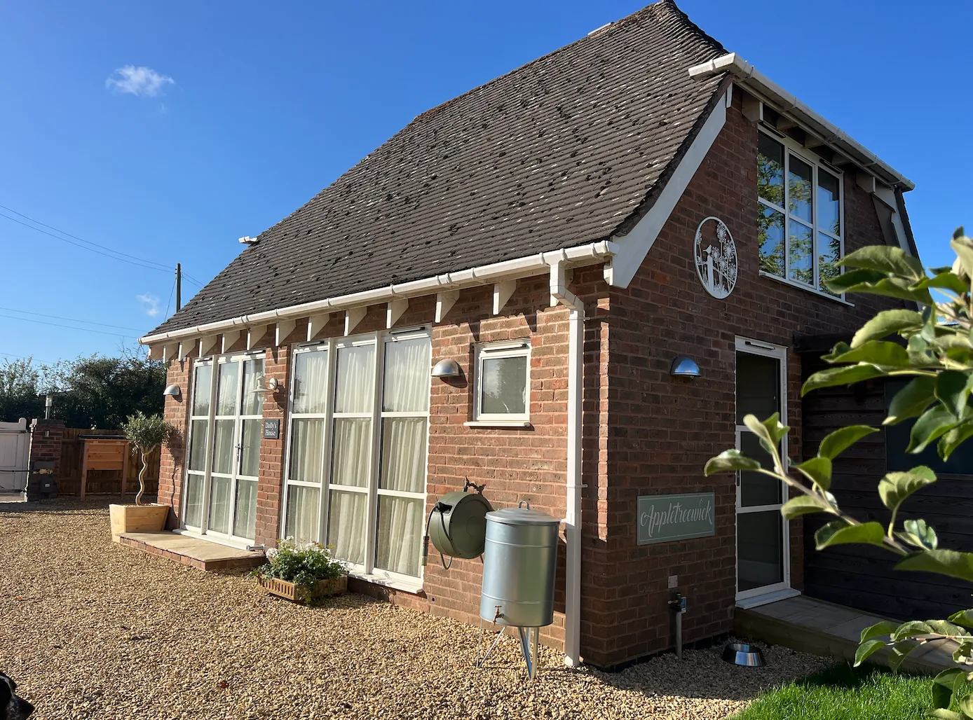 Brick garden annexe with dormer window and gravel courtyard — Dolly's House, designed for comfortable, independent living
