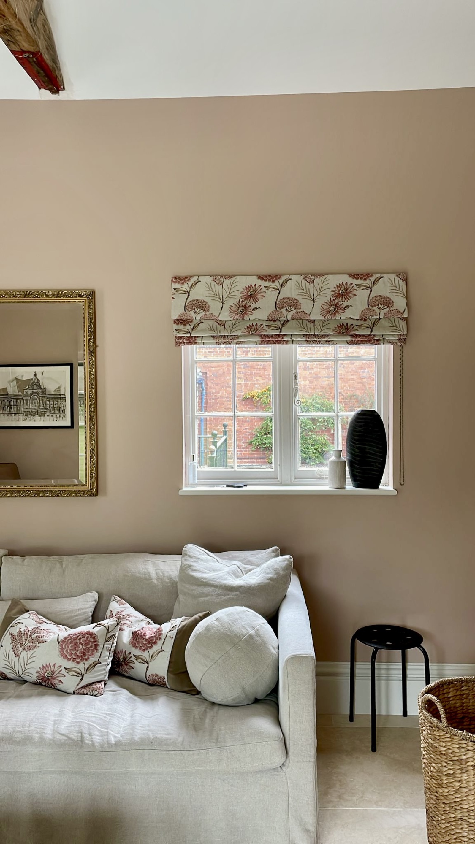 Elegant sofa with roman blind and floral cushions