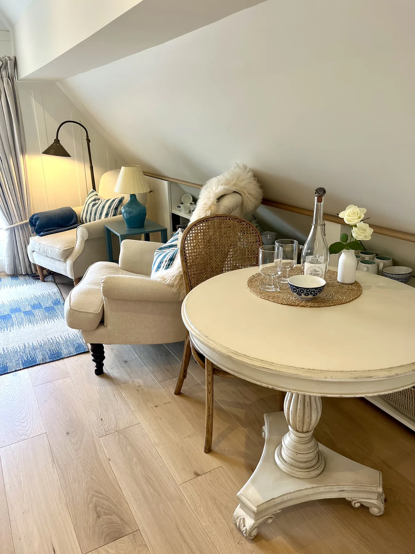 Quiet living detail — French armoire, painted dresser, and the easy flow into the next room