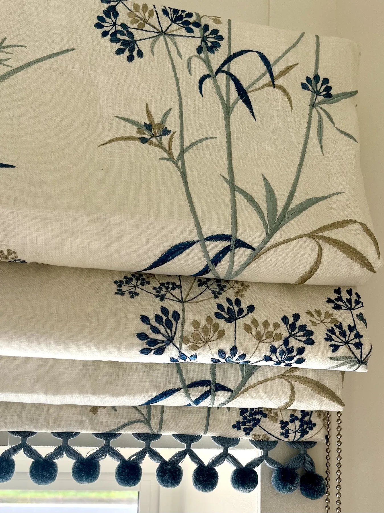Tableware and china displayed on a painted dresser, framed by botanical cushions
