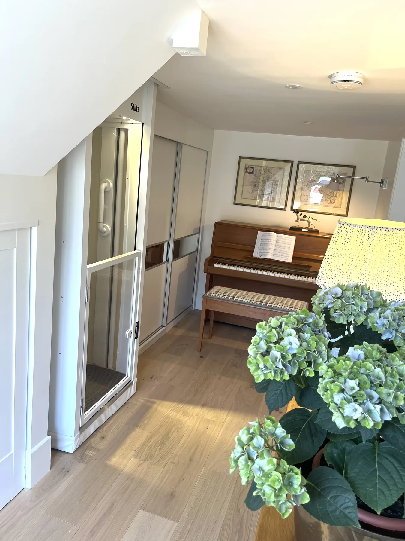 Kitchen and adjoining sitting room with sage cabinetry — open, light, and easy to move through