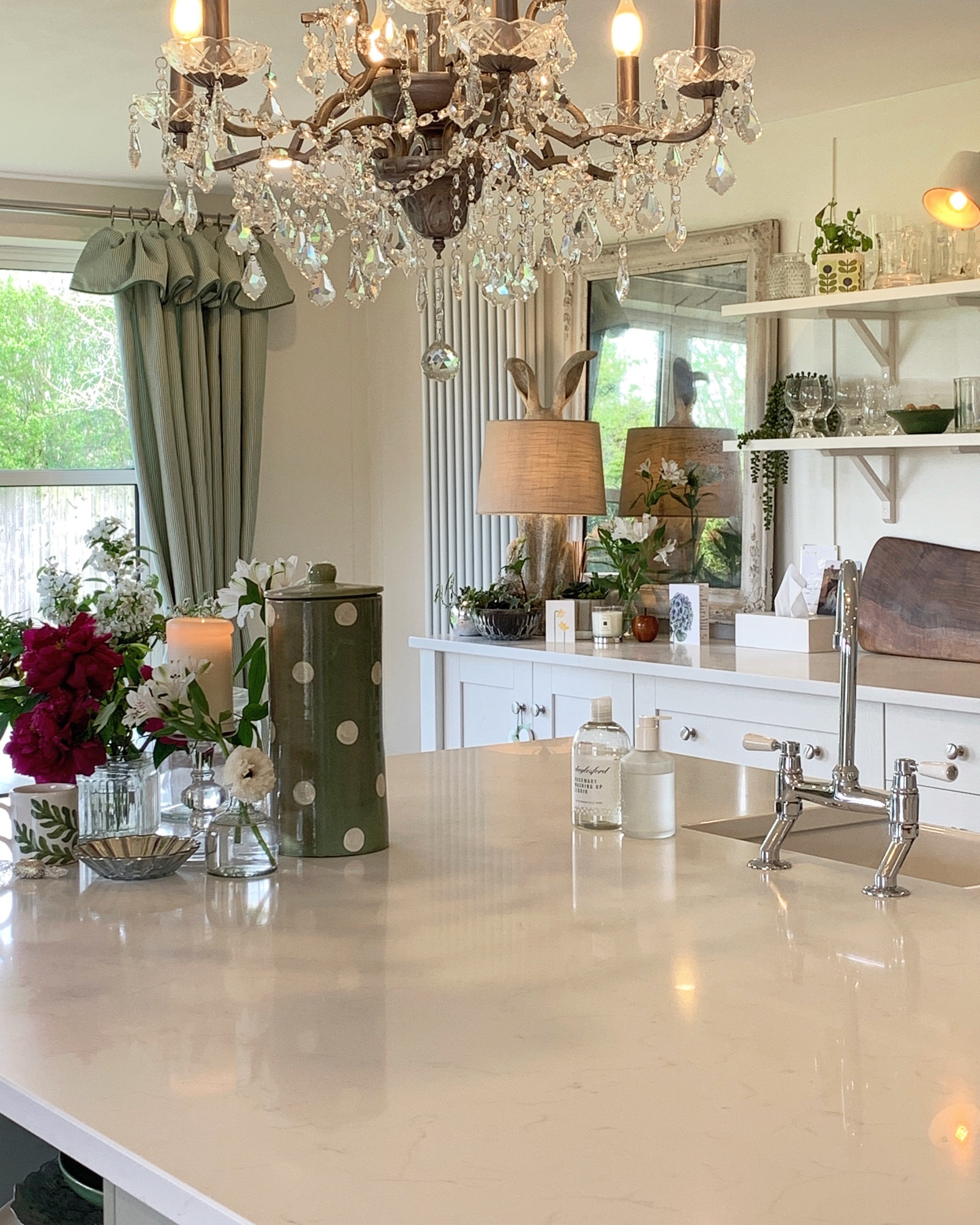 Styled countertop with chandelier, flowers, and curated details