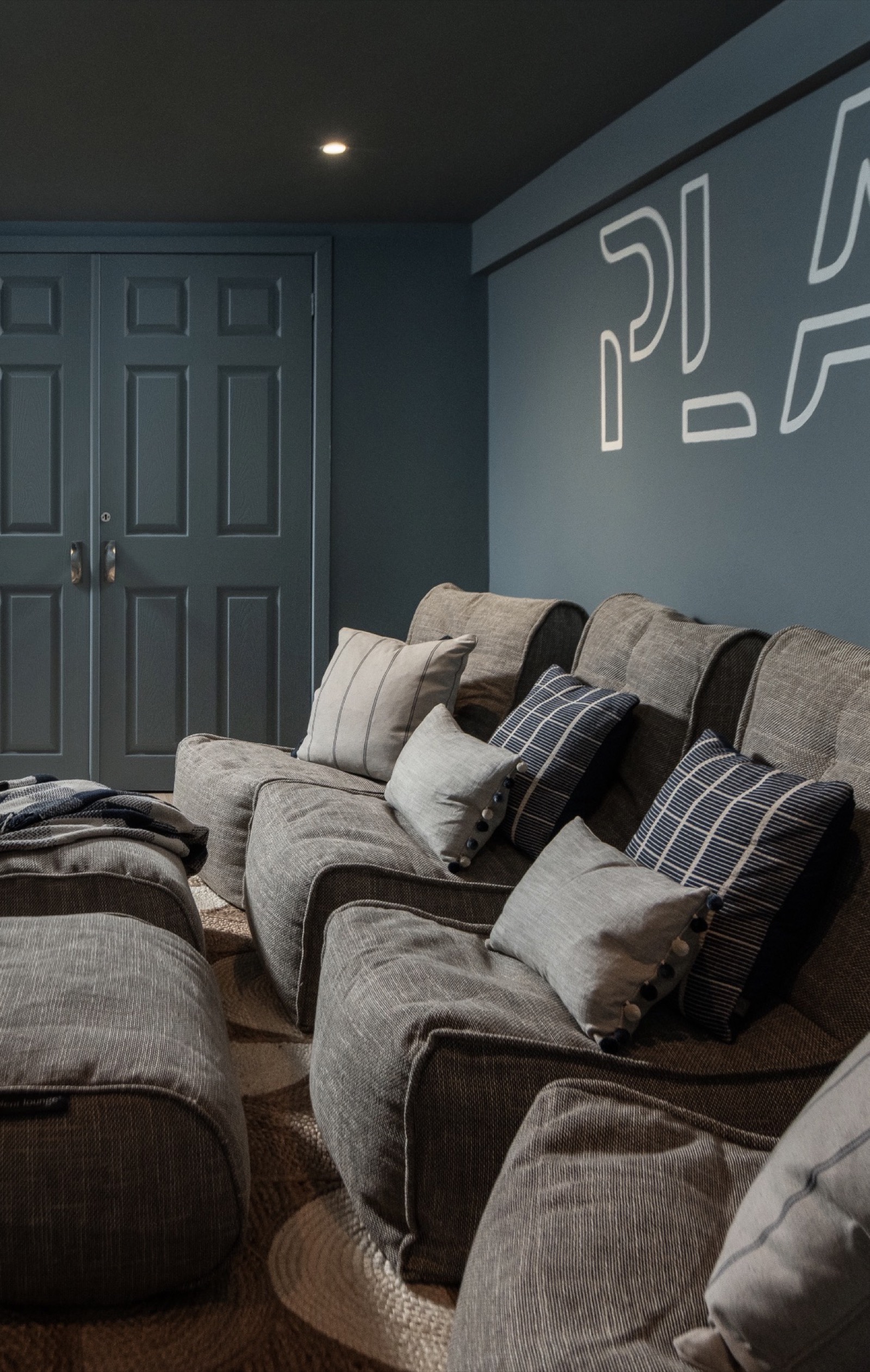 Cinema room with blue walls and neon PLAY sign