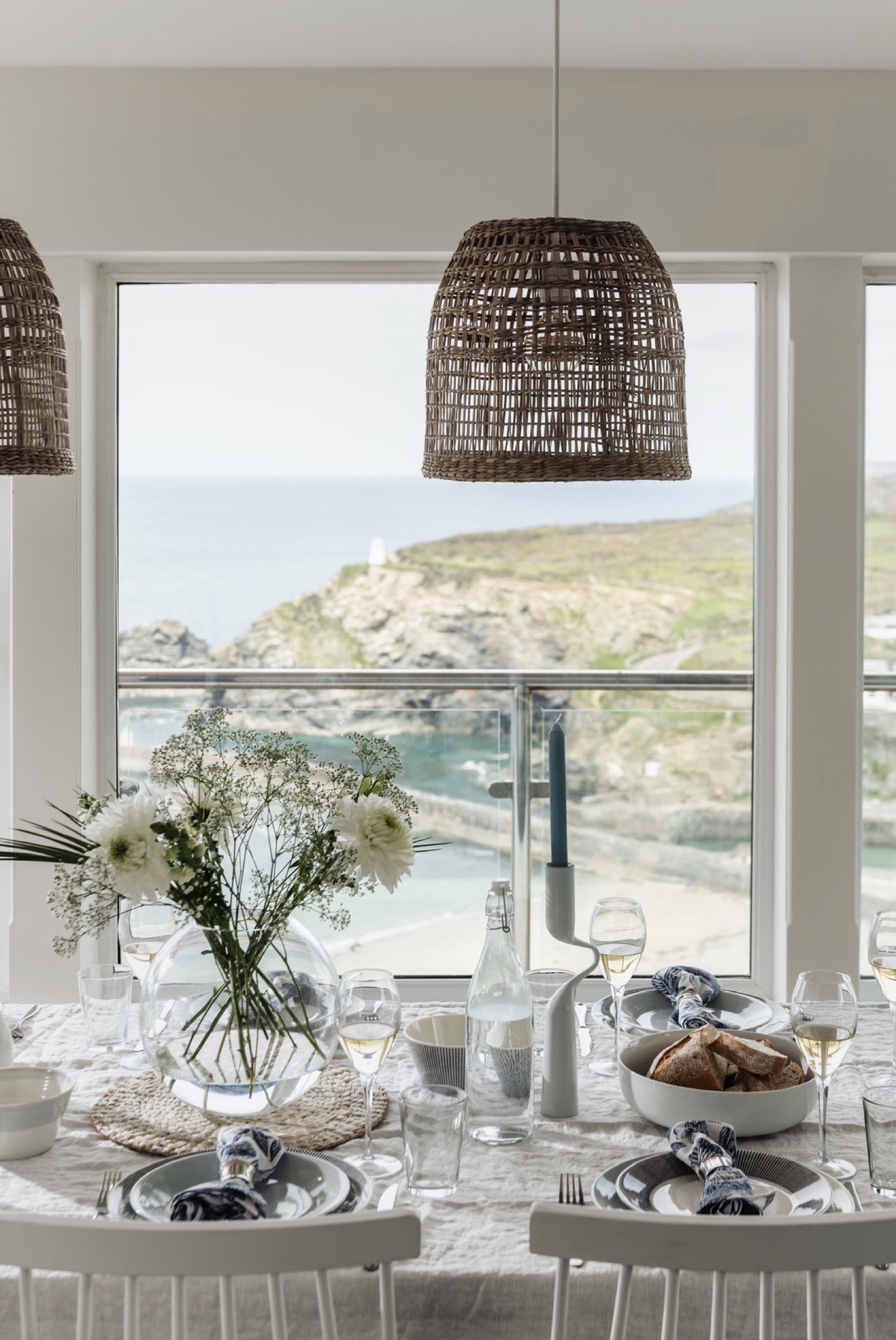 Dining room with rattan pendants and coastal panorama