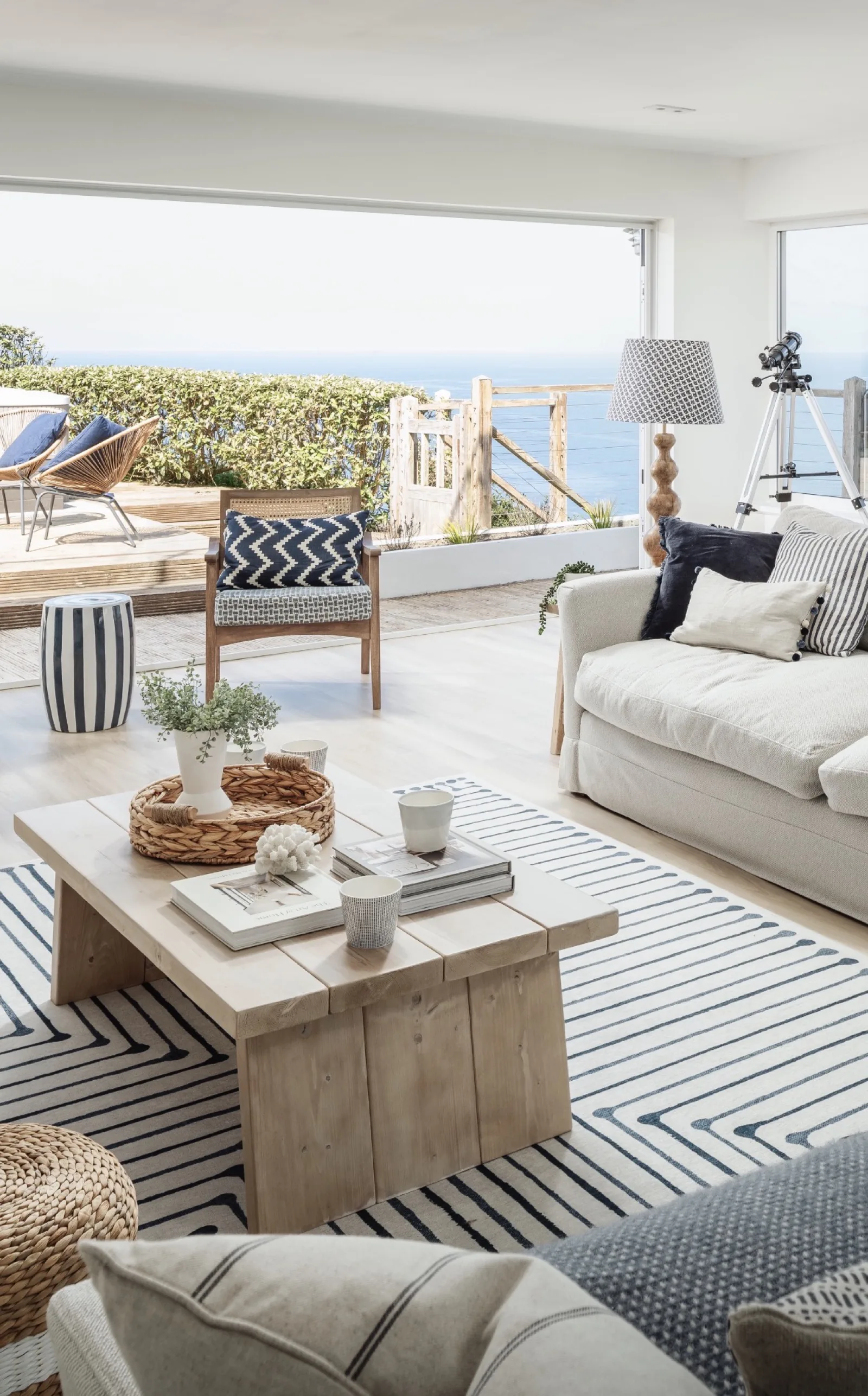 The Coastal Retreat — coastal living room opening to terrace with panoramic sea views